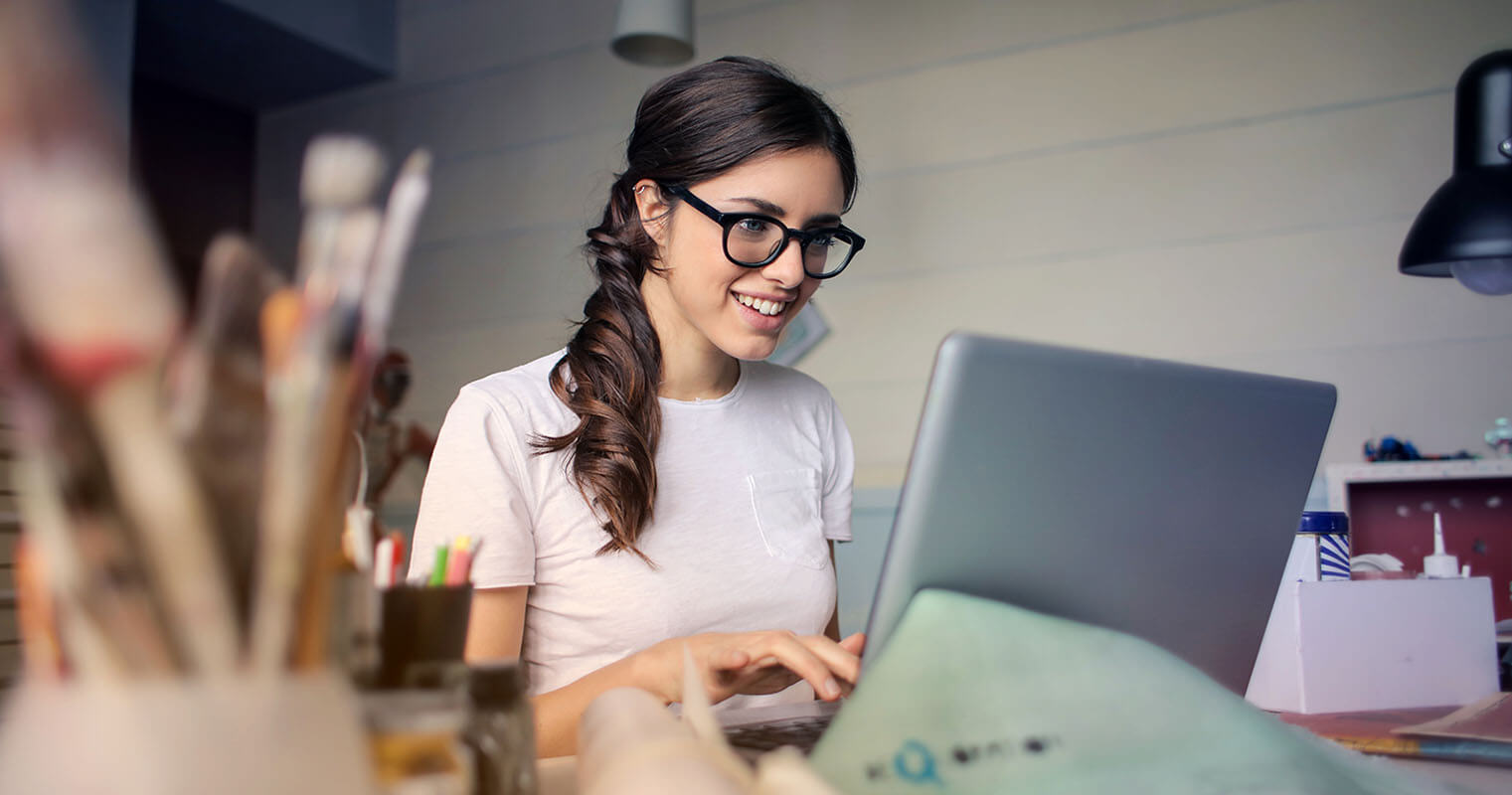 Student Using Basic Economics Online Course Happy student working on laptop